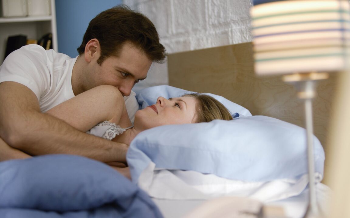 a woman in bed with a man who enlarged her penis